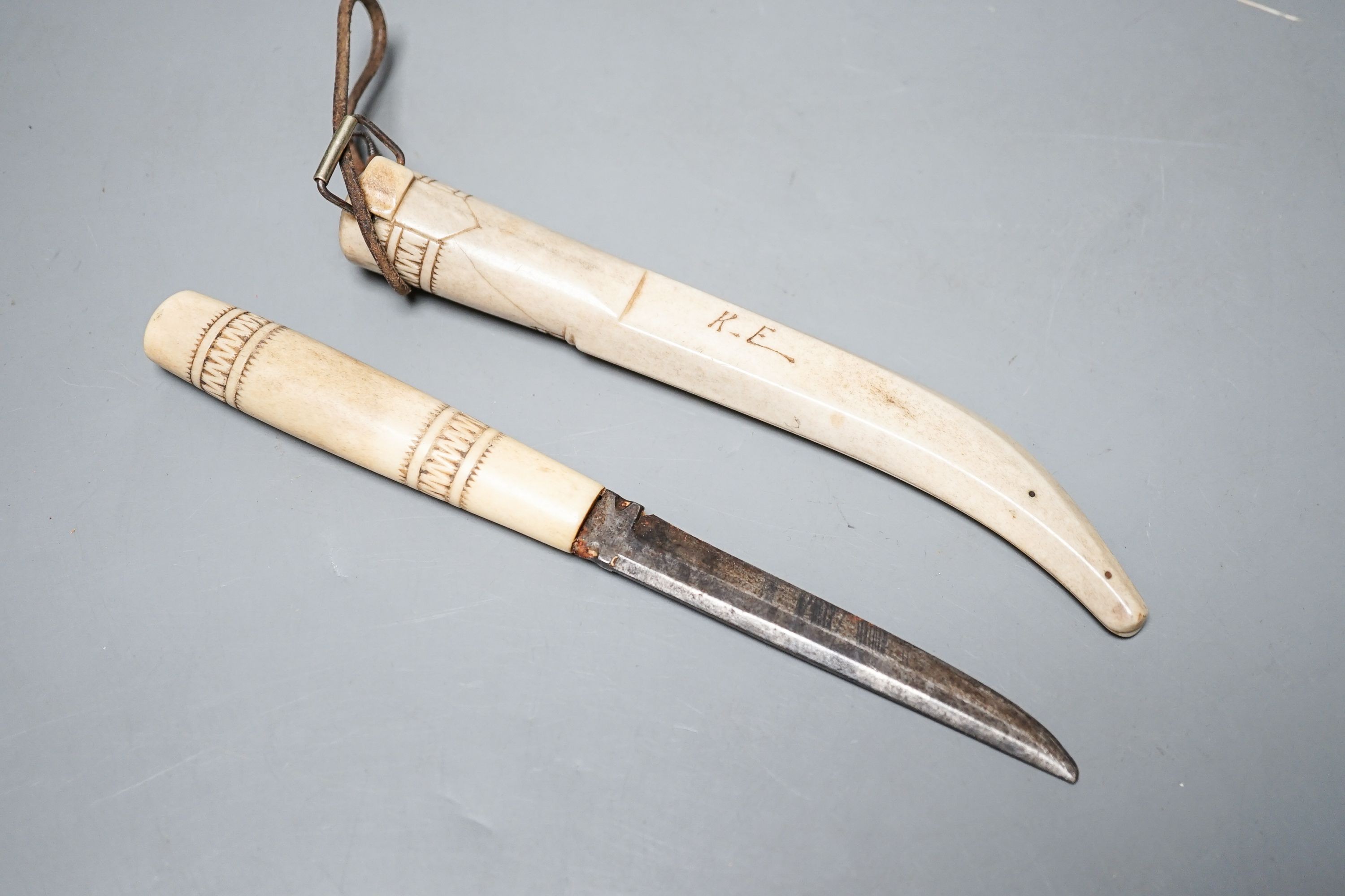 A 19th century Inuit carved stag antler dagger and scabbard, initialled ‘K.E’.